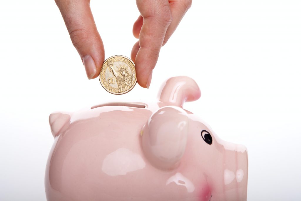 Personne plaçant des économies dans une tirelire